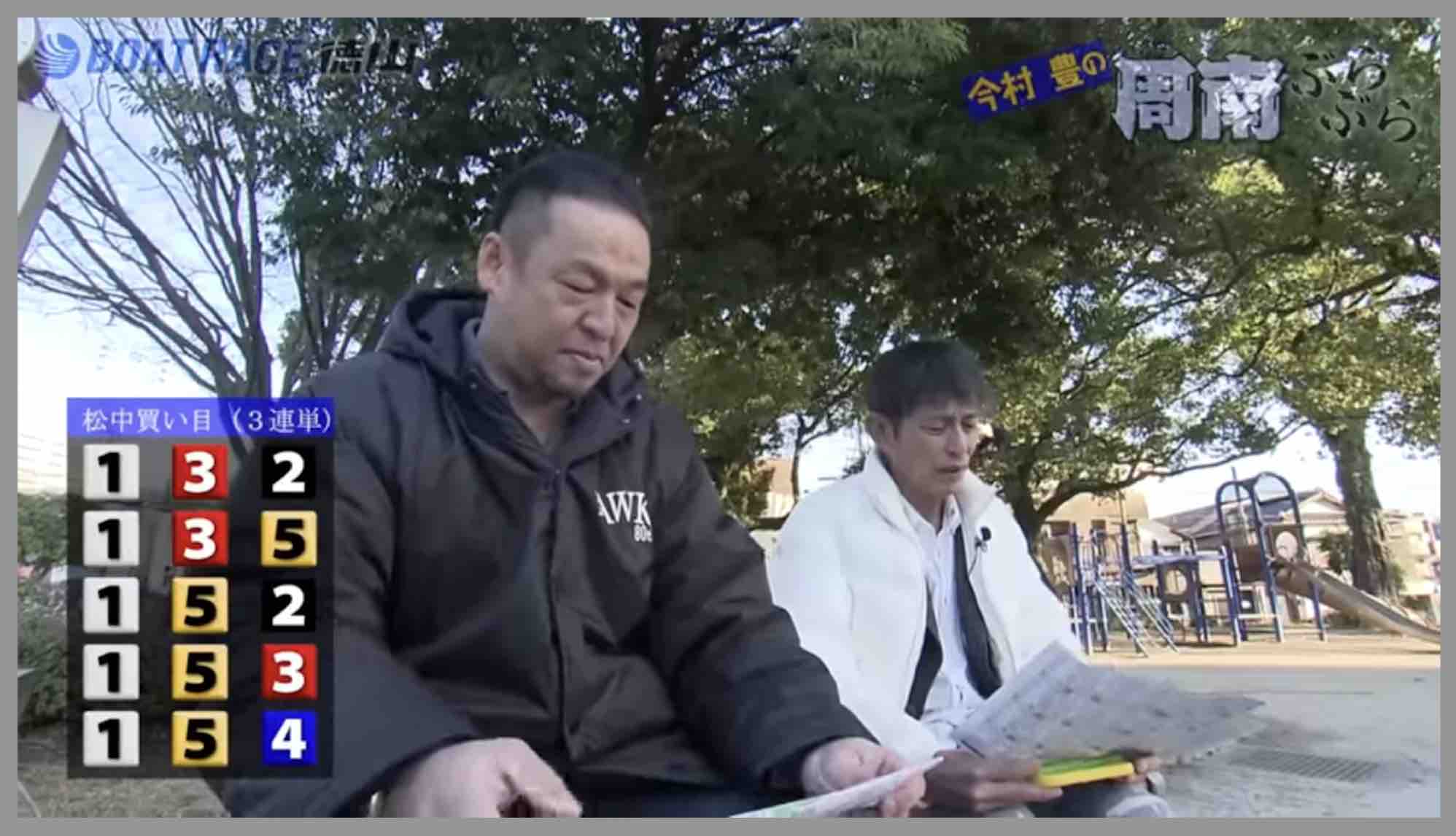 寒そうに予想結果をiPadで見る公園の2人